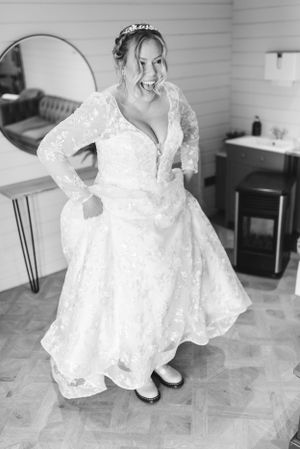 A playful black and white portrait of a bride in her lace wedding dress.