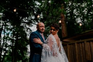 A couple poses together in a forest setting during their wedding.