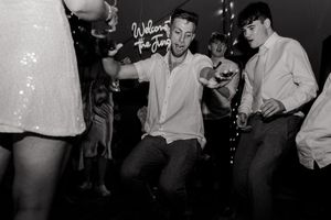 Energetic dancers move to the music at a vintage party scene captured in black and white photography.