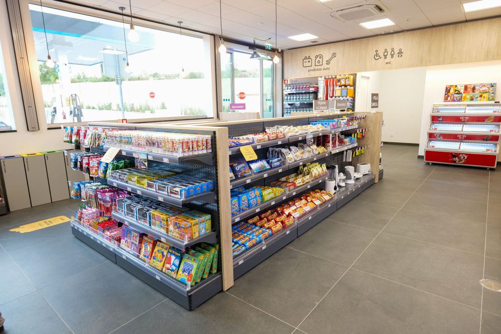 Interior of Prio Pronto convenience store showing snack and food product shelves with refrigerator units.