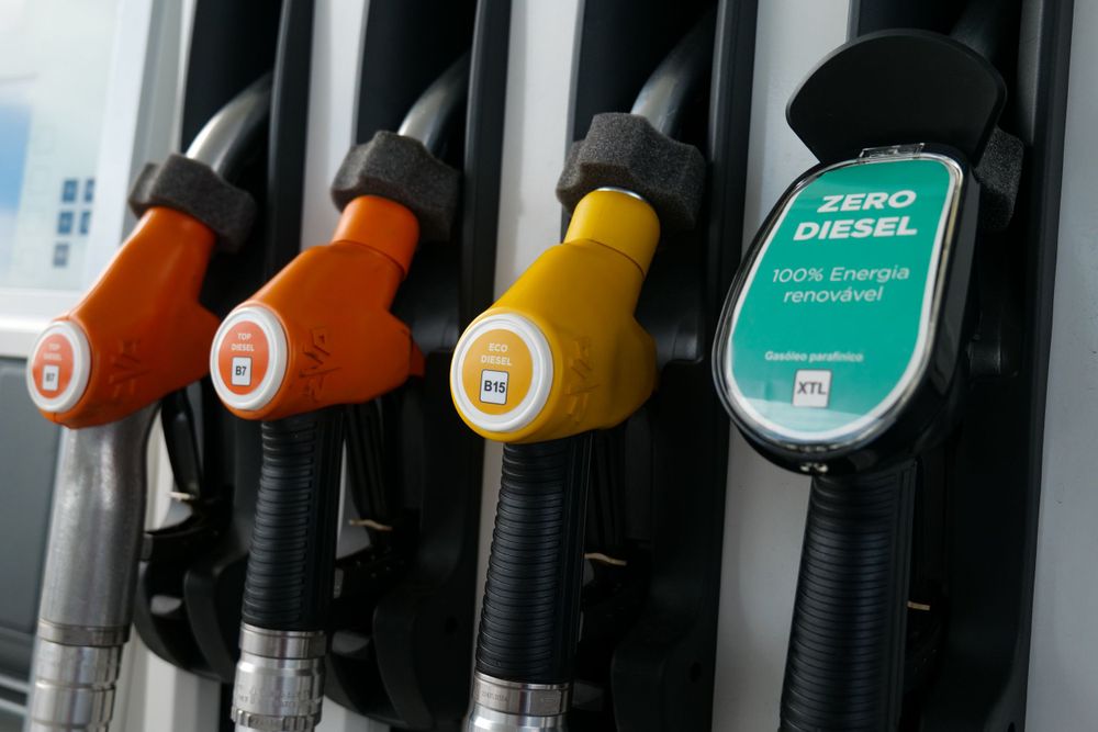 Close-up of colorful fuel pump nozzles including Zero Diesel 100% renewable energy option at a gas station.