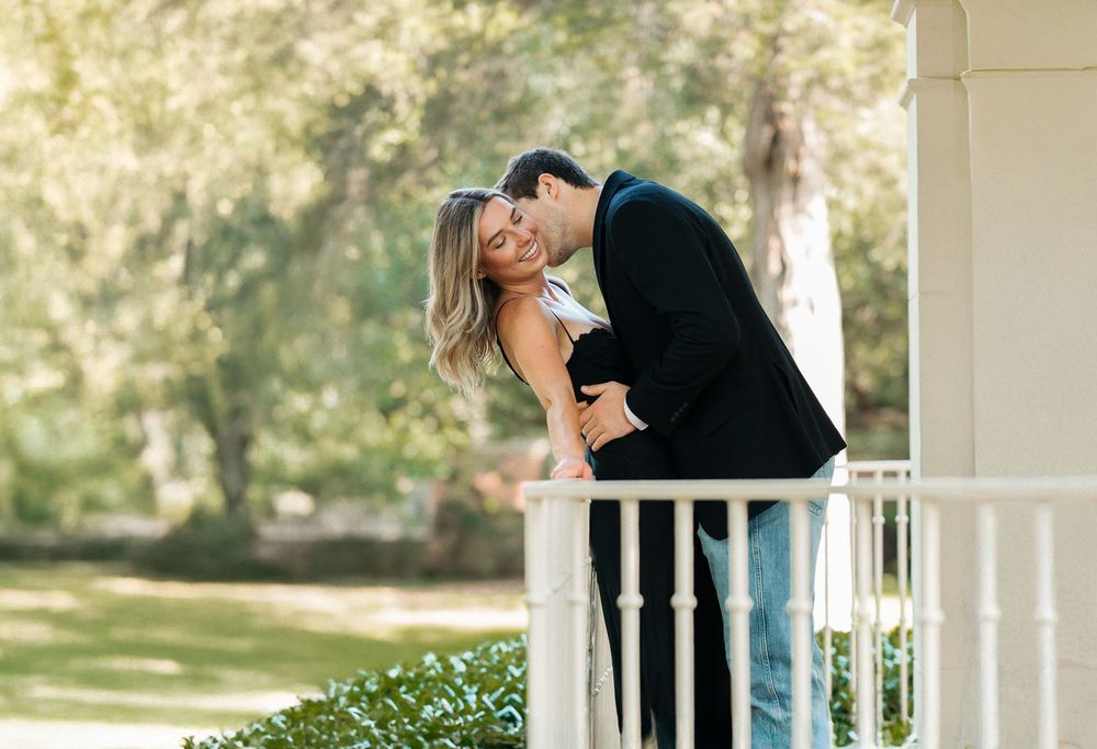 Bride and groom kiss on wraparound porch – Southern-style wedding in Texas
