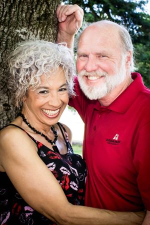 Happy mature couple embracing outdoors with genuine laughter.