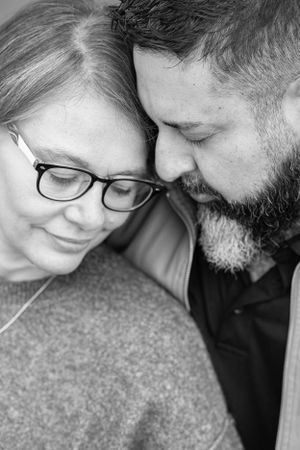 Intimate black and white close-up portrait showing tender moment between couple.