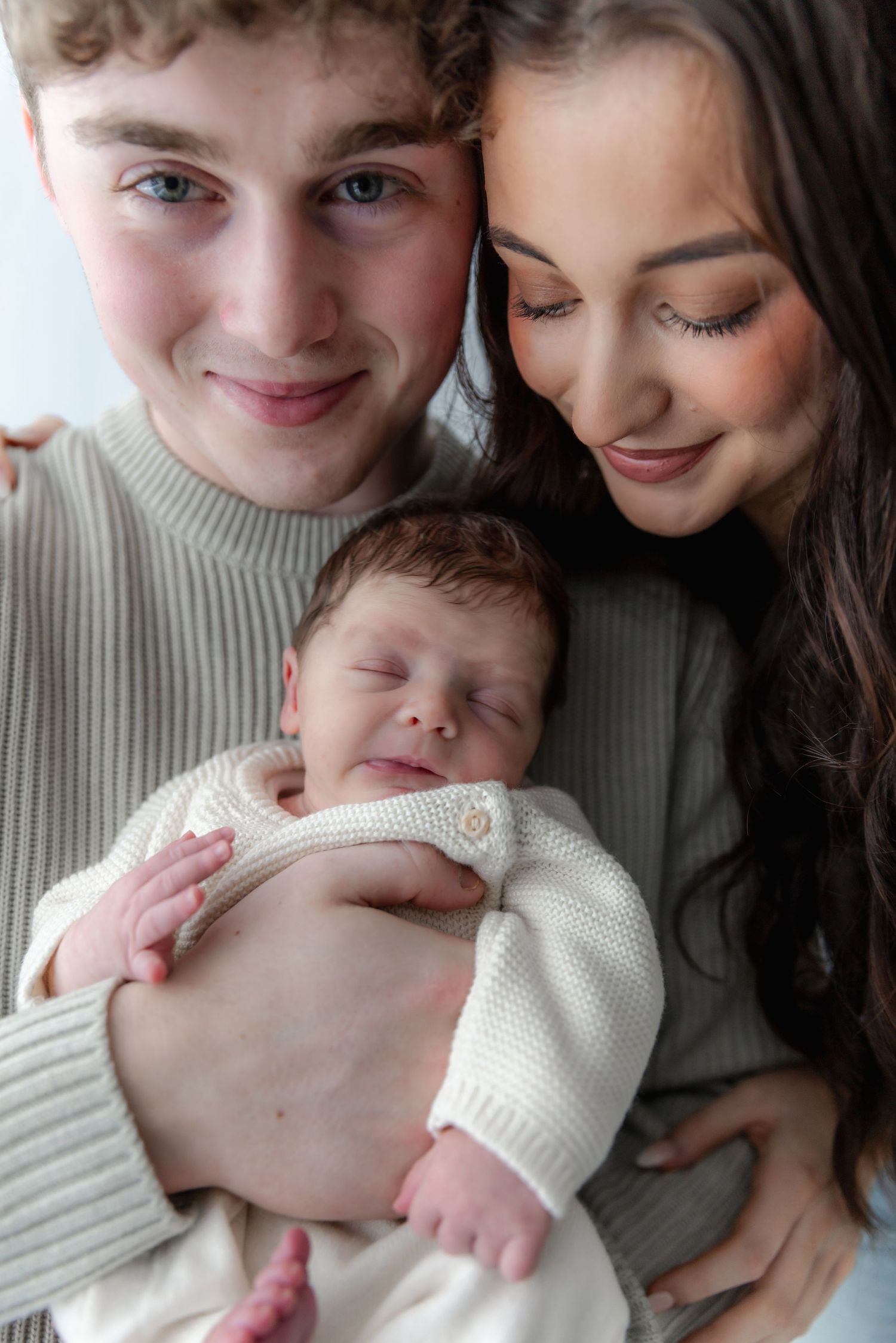 A collection of close-up color photos showing gentle interactions between a couple and a newborn baby.