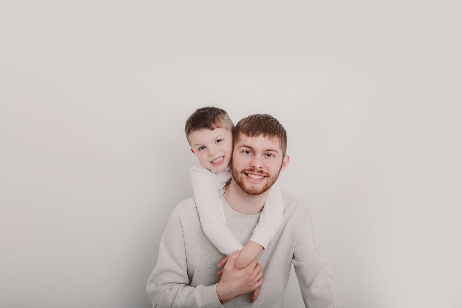 Family members embrace during casual portrait session in light colored clothing. Photographer. Hull. East Yorkshire. Photography