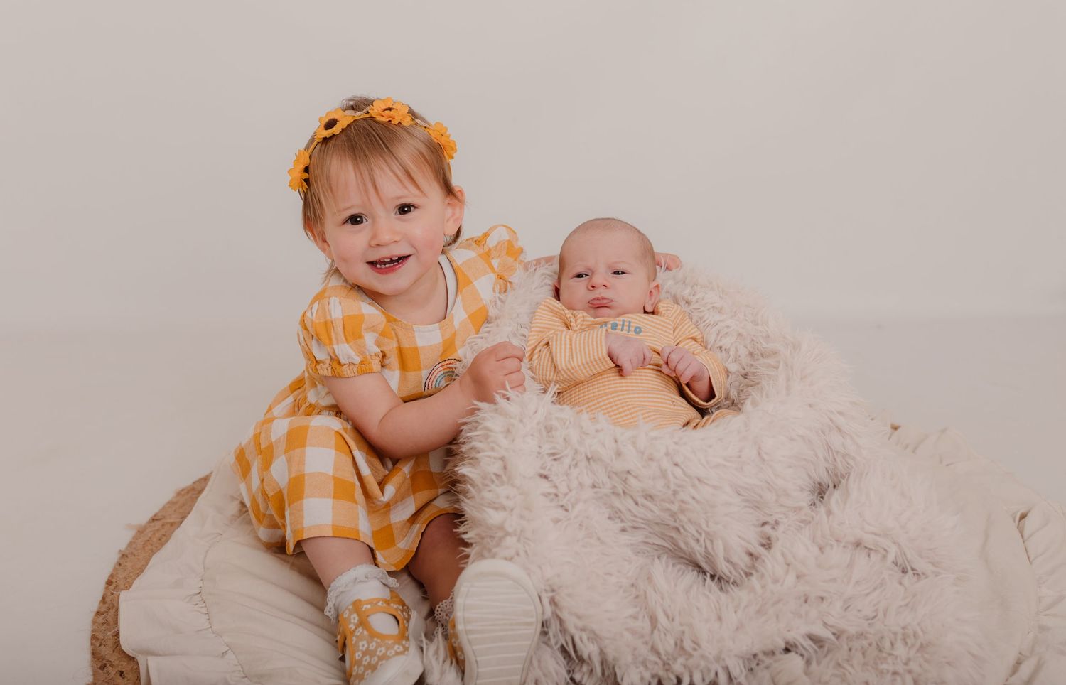 Family photo series in warm yellow tones with cozy blankets and natural lighting.
