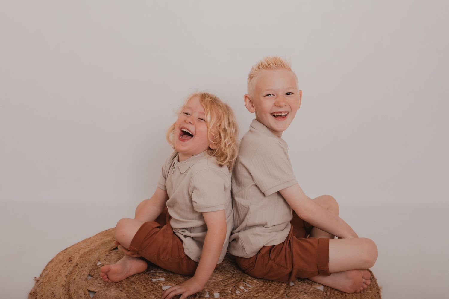 A joyful family photo session with natural expressions and laughter against a light gray backdrop. Photographer. Hull. East Yorkshire. Photo