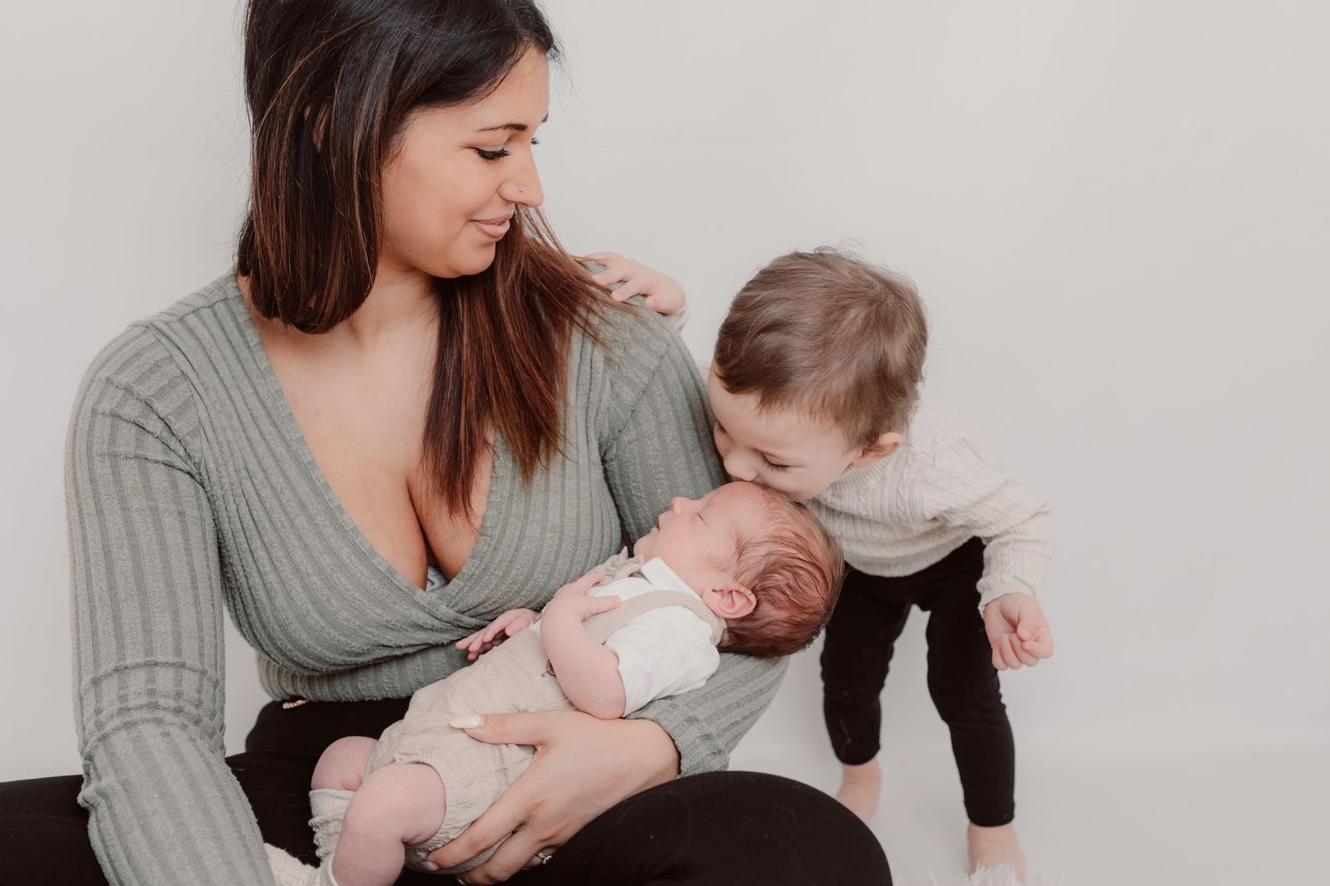 Mother in grey sweater holding and bonding with her children during an intimate photo session. Photographer. Hull. East Yorkshire. Photograp