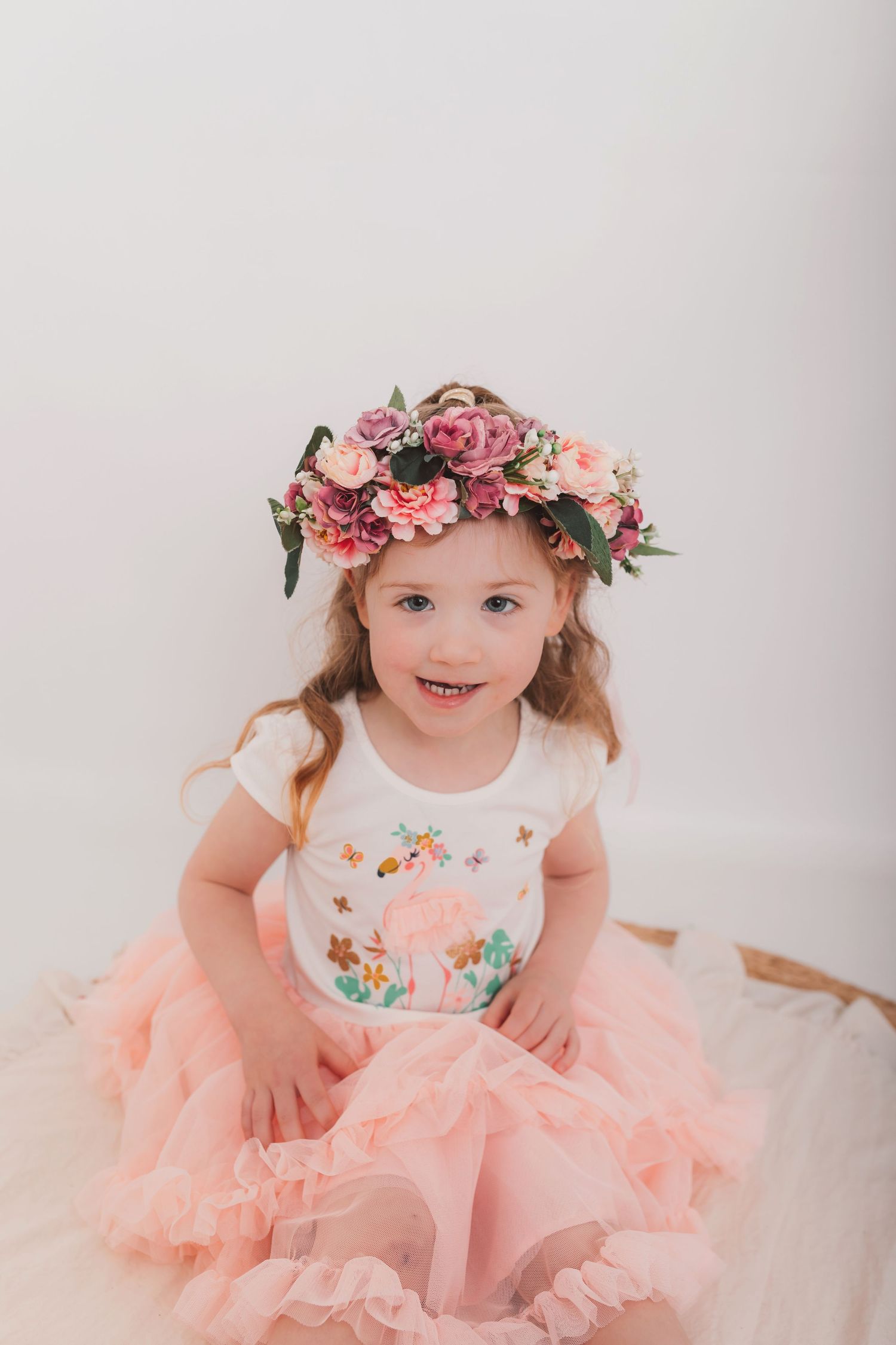 Child in pink tulle dress wearing floral crown poses for portrait. Photographer. Hull. East Yorkshire. Photography