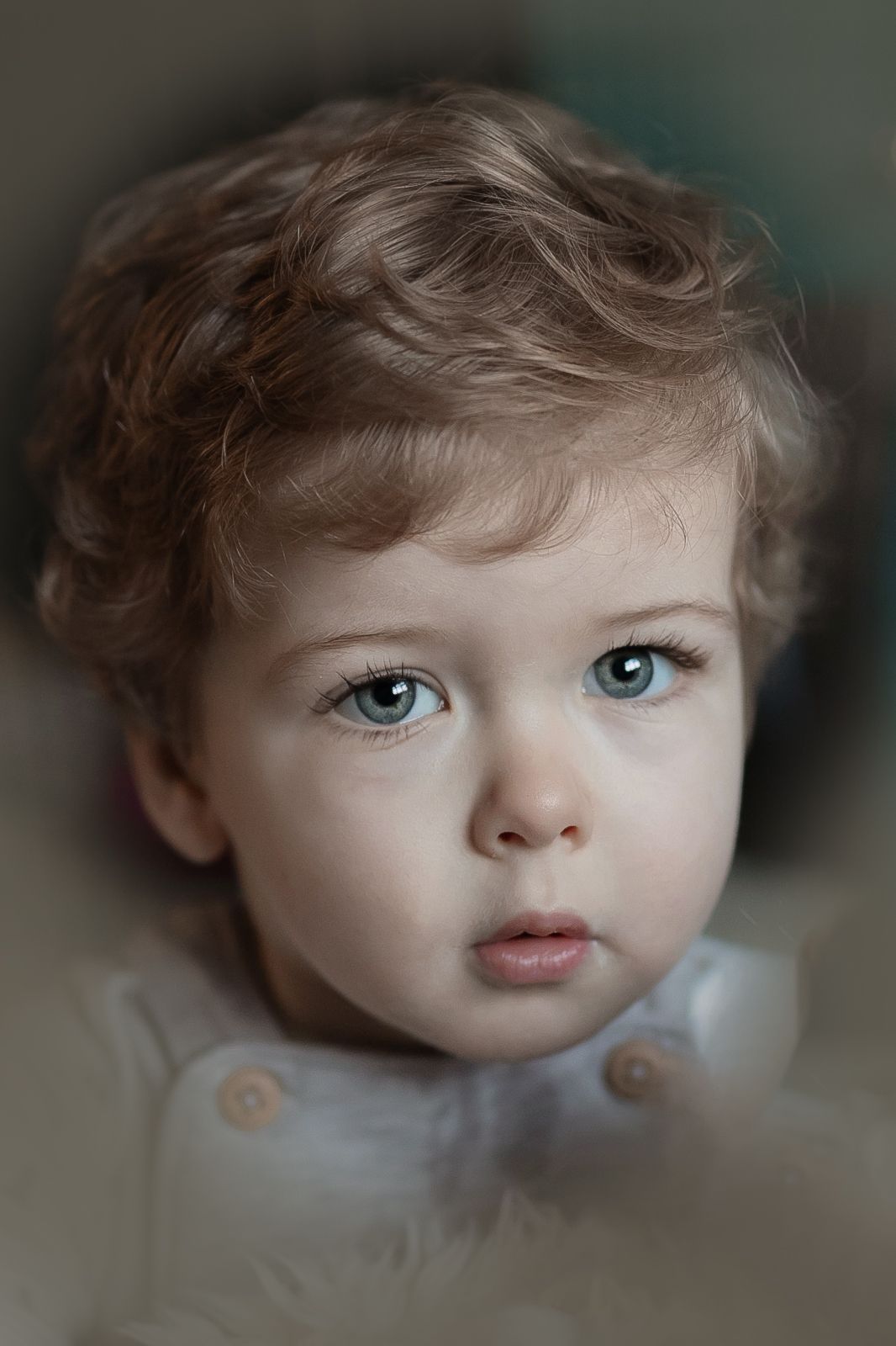 Close up portrait of a young child with curly hair and striking blue eyes looking at the camera. Photographer. Hull. East Yorkshire. Photo