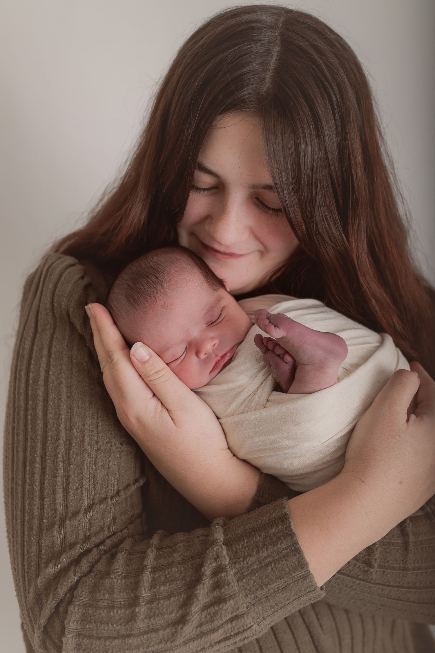 Heartwarming series of tender moments with newborn baby in cream coloured wrap. Photographer. Hull. East Yorkshire. Photography