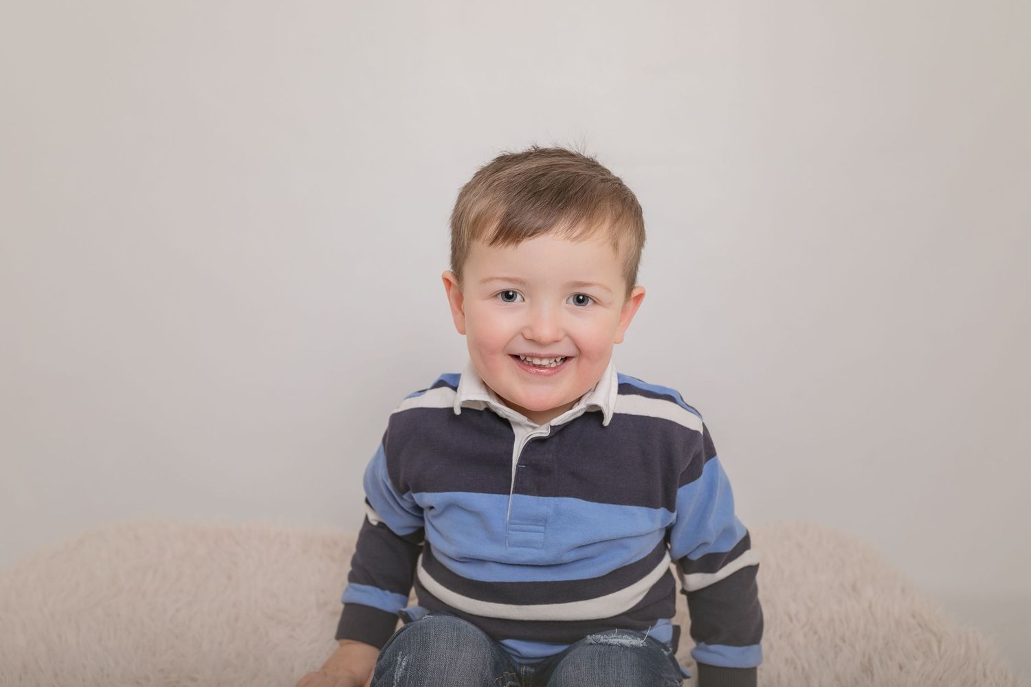 A cheerful portrait of a child in a striped rugby shirt. Photographer. Hull. East Yorkshire. Photography