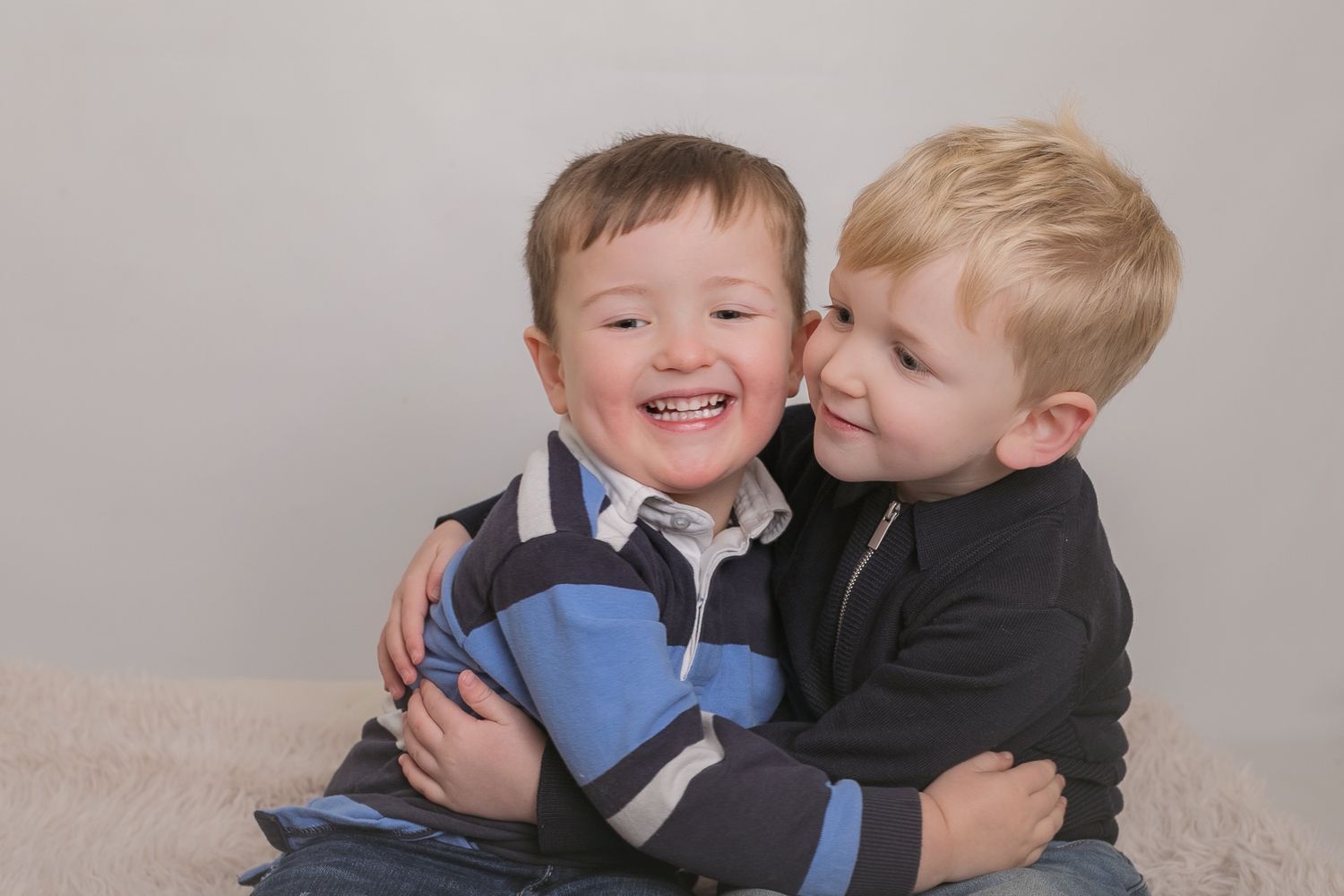 Two children share a sweet embrace while laughing together. Photographer. Hull. East Yorkshire. Photography