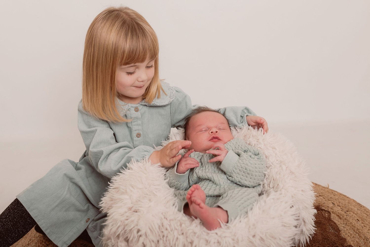 Professional family portrait session with neutral tones and coordinated outfits against light background. Photographer. Hull. East Yorkshire