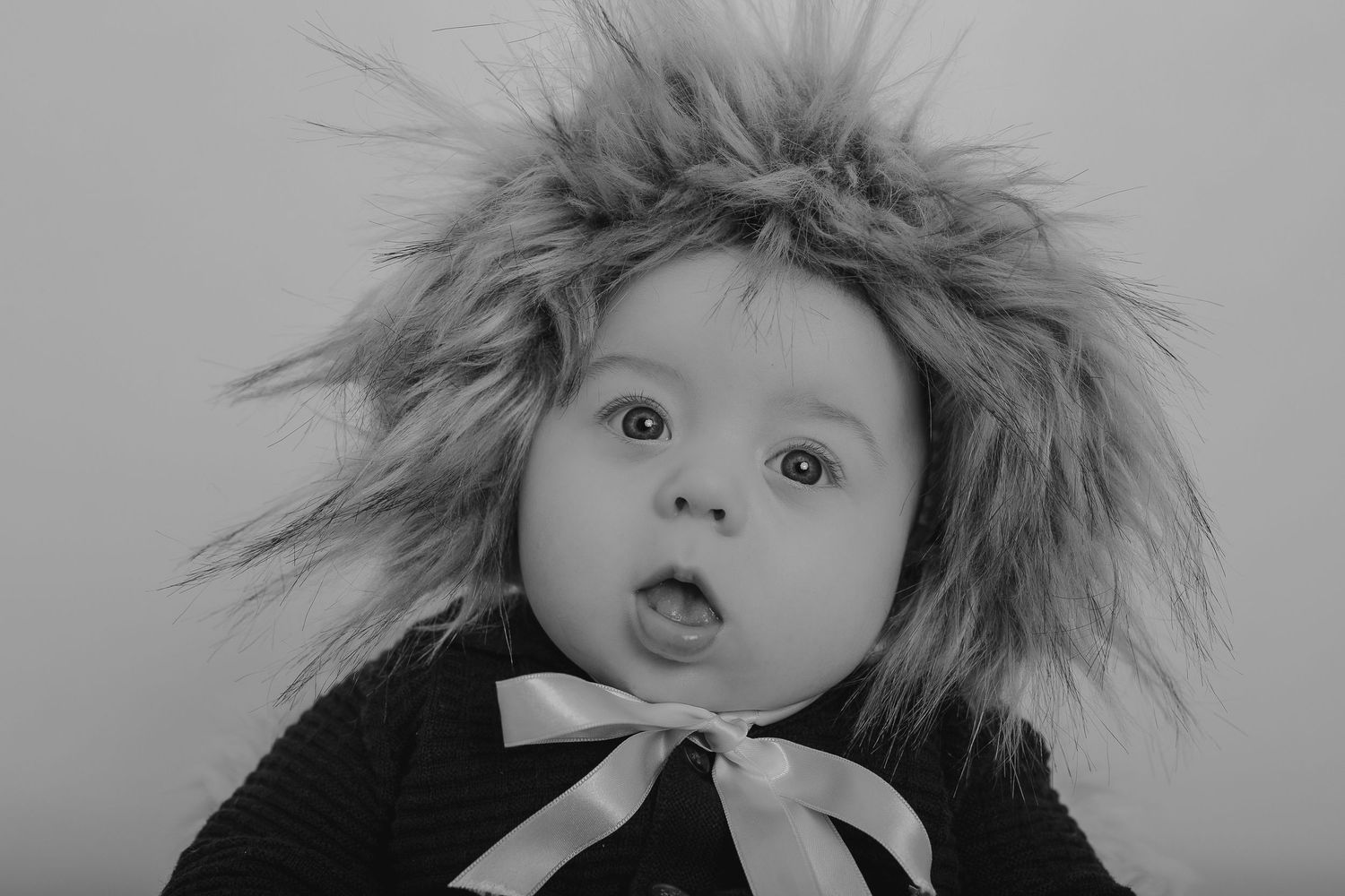 Series of artistic black and white portraits showing a baby with fur hat against white background.  Photographer. Hull. East Yorkshire.