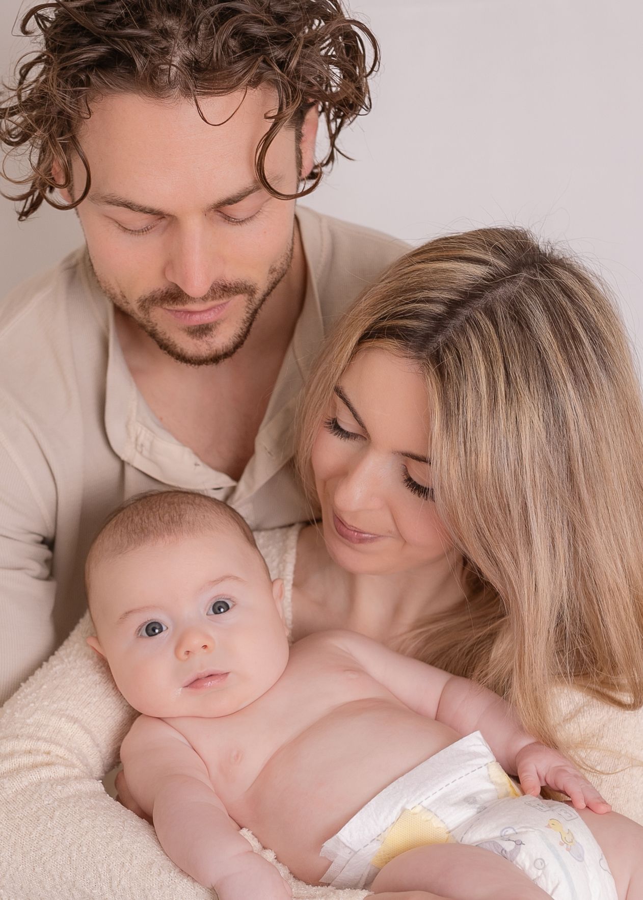 Intimate family portrait series showing tender moments between parents and baby in neutral tones.  Photographer. Hull. East Yorkshire. Photo