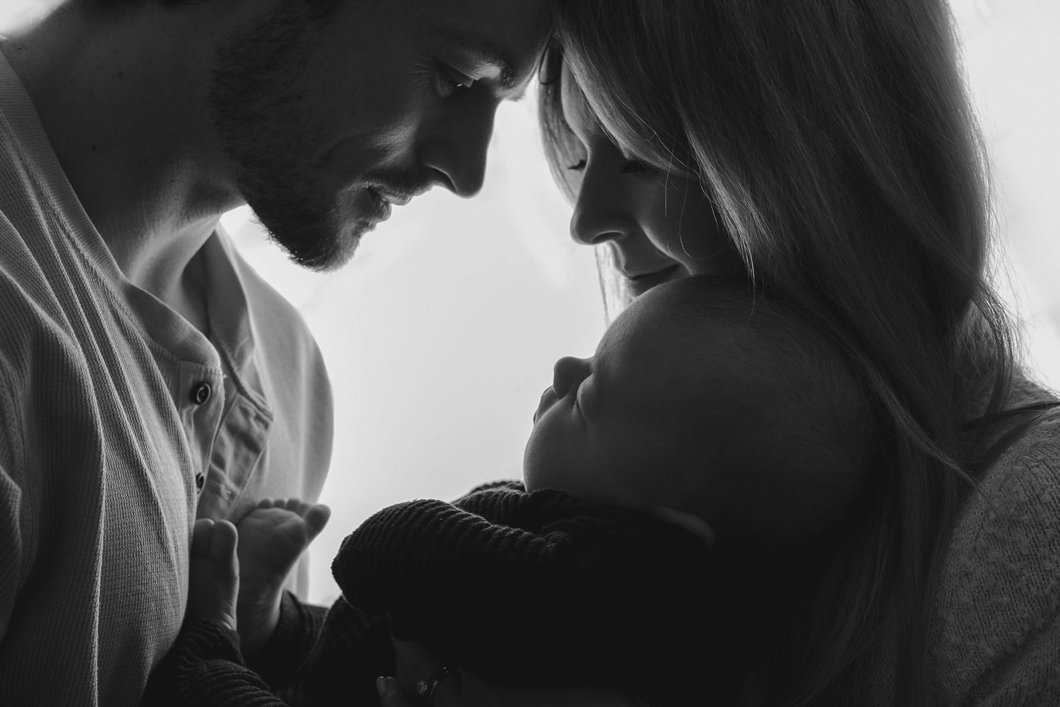 Silhouette portrait of parents gazing lovingly at their newborn baby.  Photographer. Hull. East Yorkshire. Photography