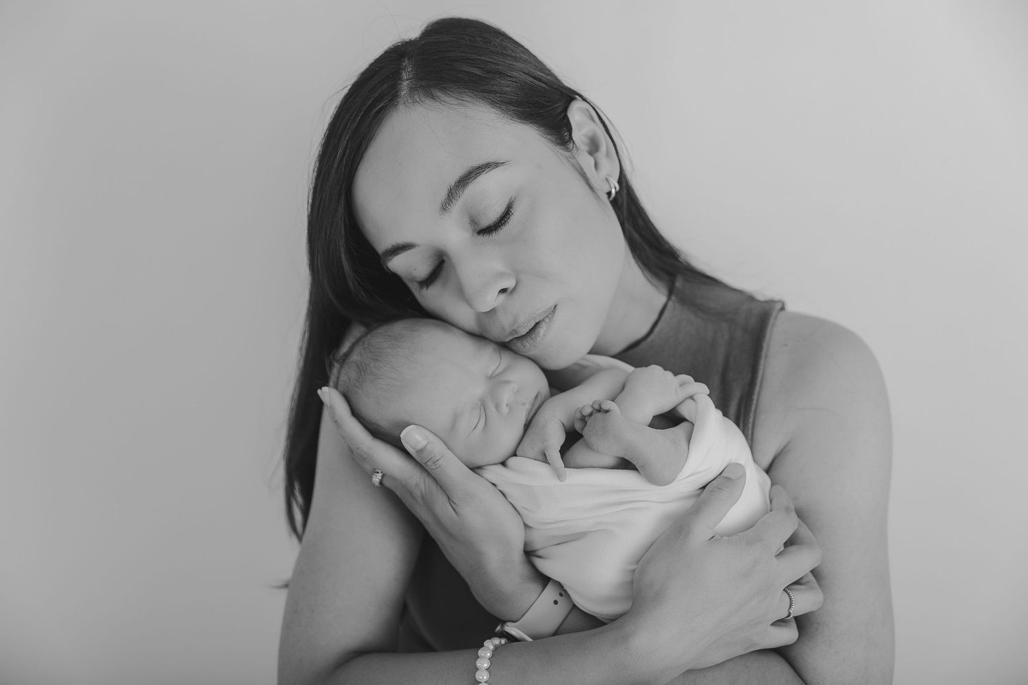 Tender black and white portrait of parent holding sleeping newborn against their cheek.  Photographer. Hull. East Yorkshire. Photography