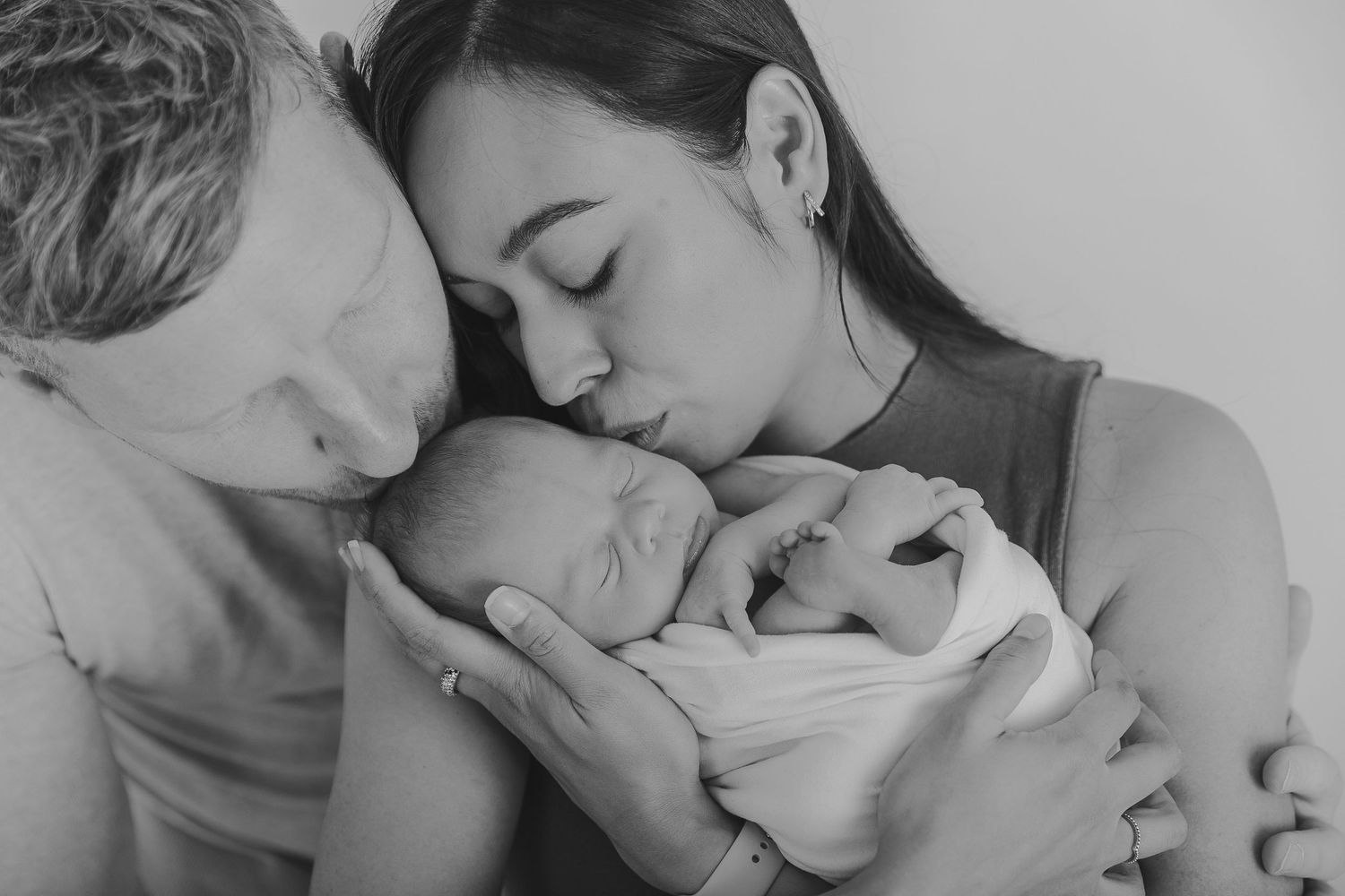 Black and white portrait of parents snuggling their sleeping newborn.  Photographer. Hull. East Yorkshire. Photography