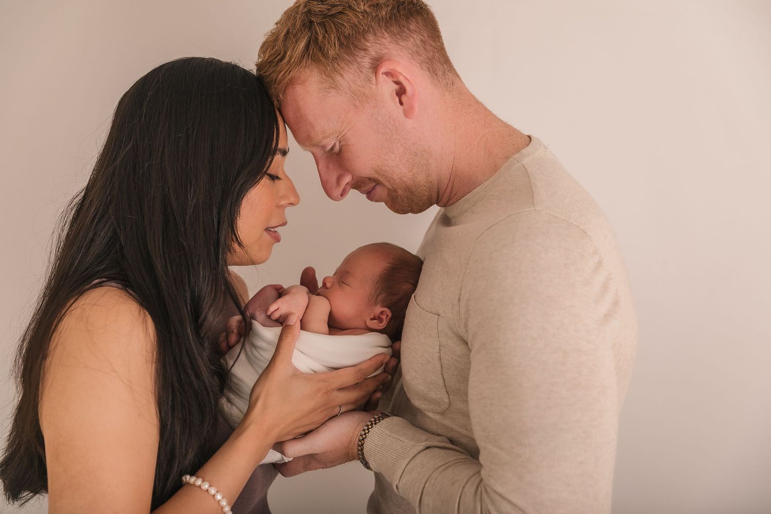 Intimate colour photo of parents sharing a tender moment with their newborn baby.  Photographer. Hull. East Yorkshire. Photography