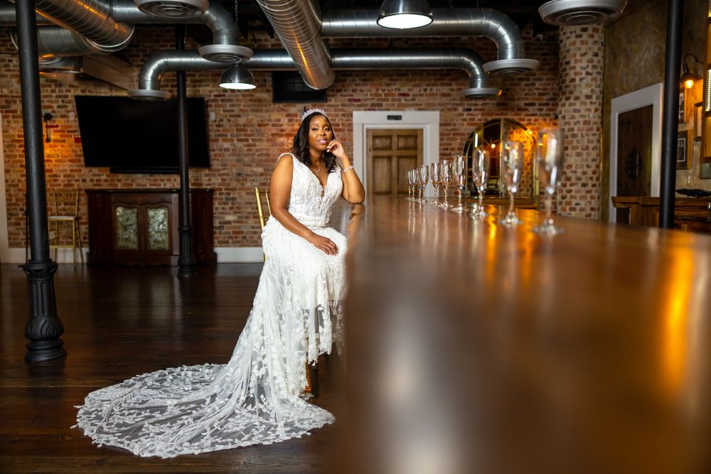 Stunning bridal portrait in industrial venue with long train lace dress.