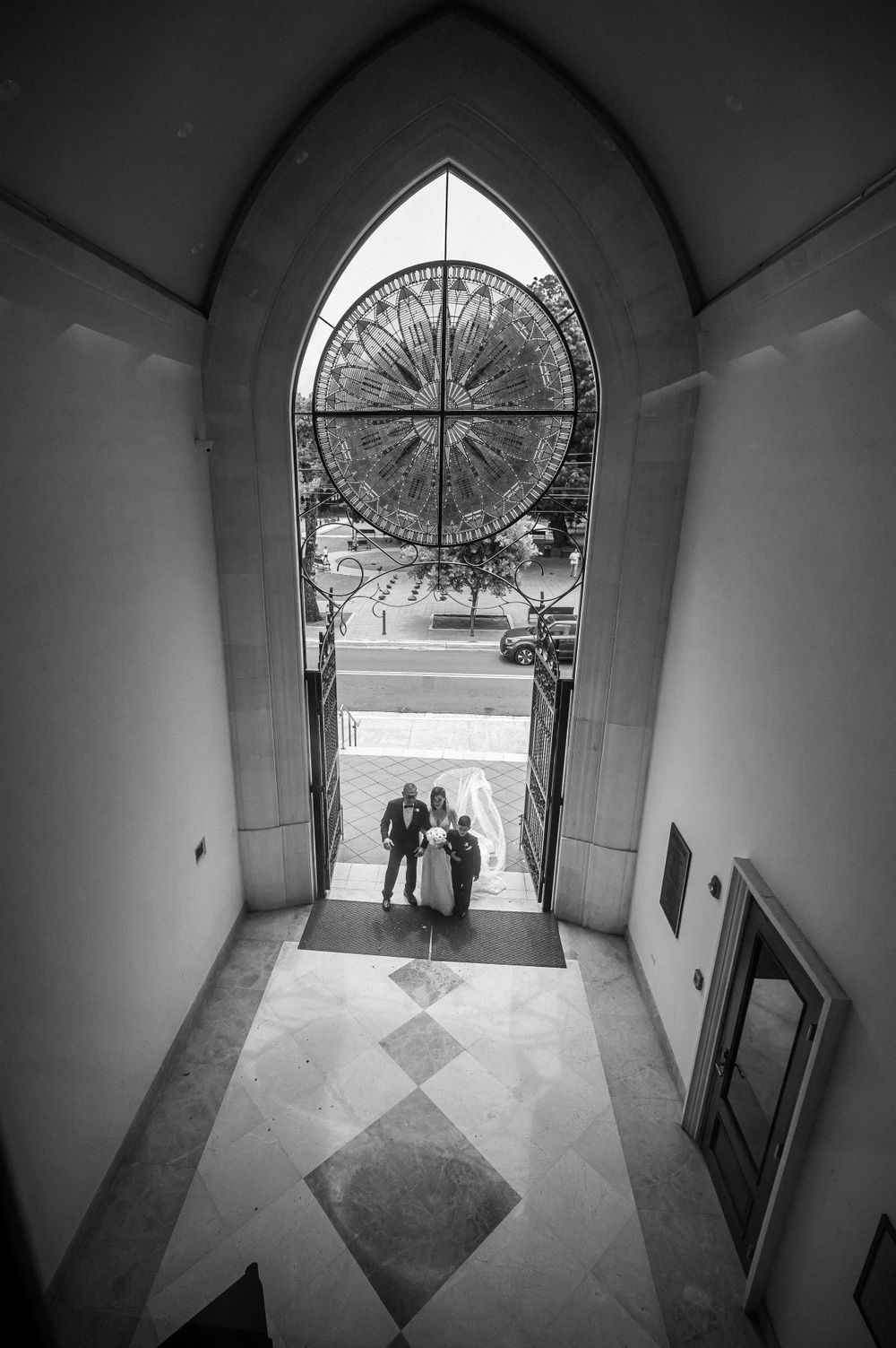 Black and white view through arched doorway with ornate compass design overhead.