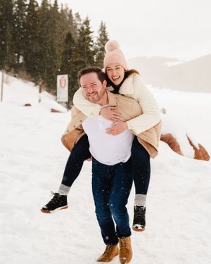 A joyful piggyback ride moment captured in a snowy winter setting.