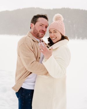 A newly engaged couple sharing a happy moment in their winter outerwear.