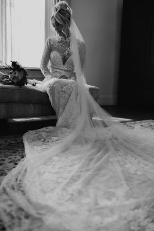 Black and white photo series showing the intricate details of a flowing lace wedding dress and veil in natural light.