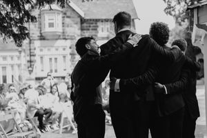 A black and white photo collage showing people greeting and embracing each other at what appears to be a reunion.