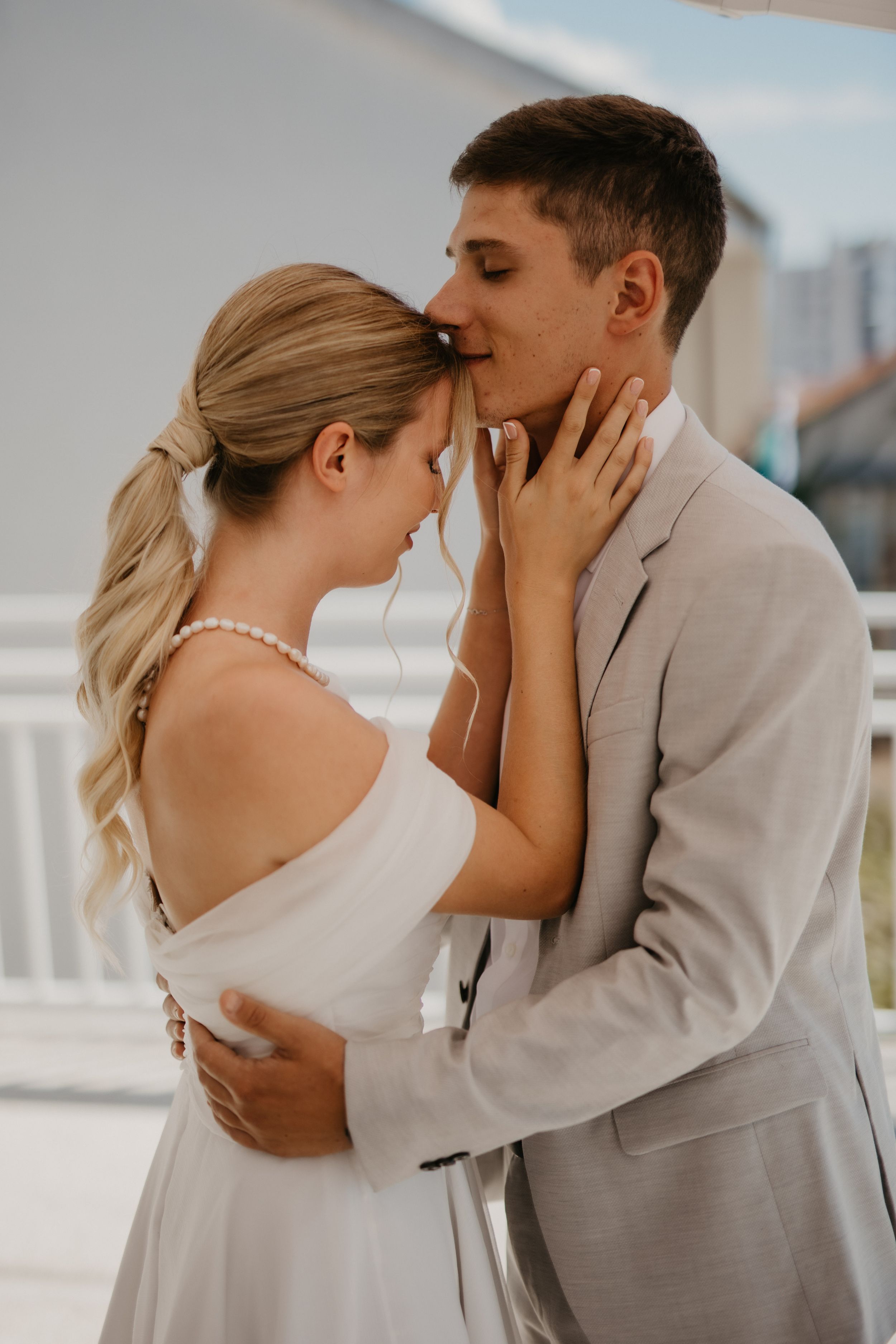 An intimate moment between newlyweds sharing a romantic embrace outdoors.