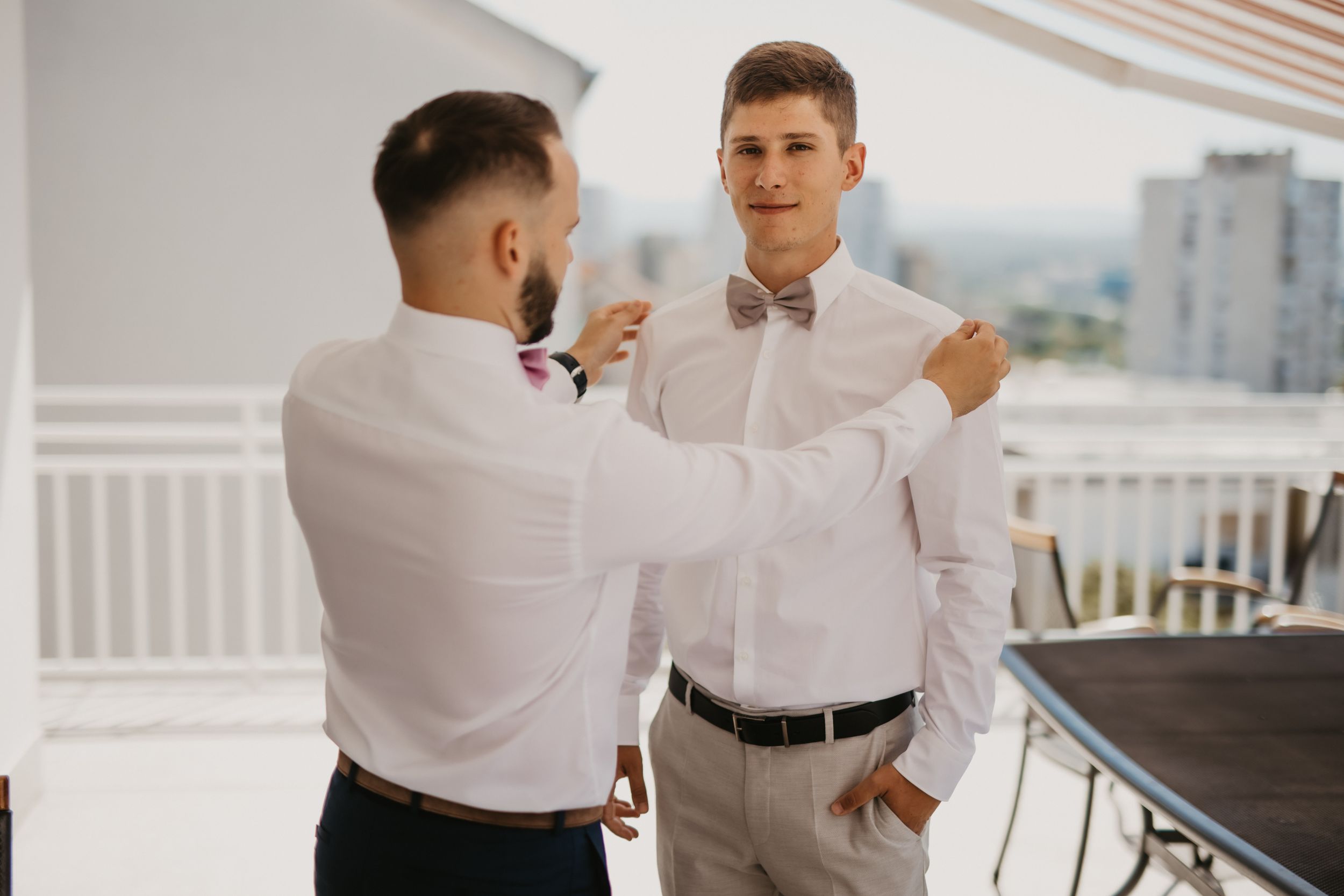 Final adjustments being made to formal attire on outdoor terrace.