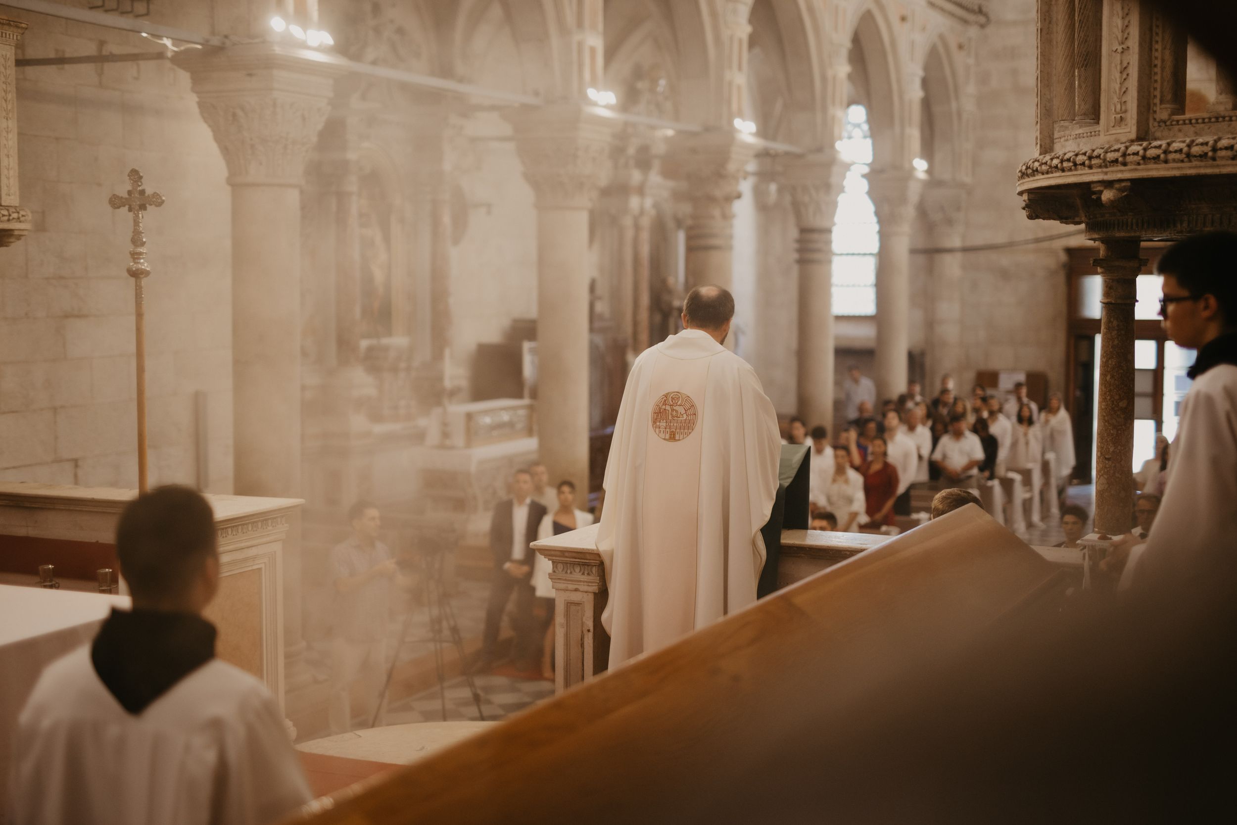 Catholic wedding mass with priest and altar servers in historic church interior.