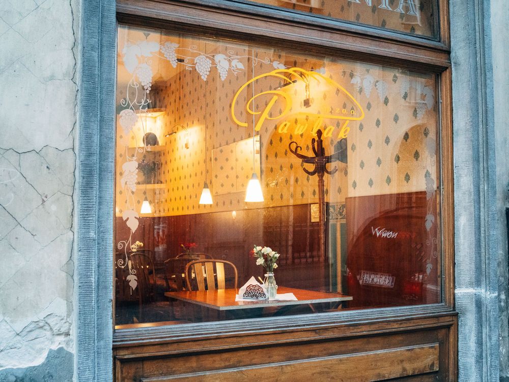 Illuminated cafe window display with warm lighting and reflections.