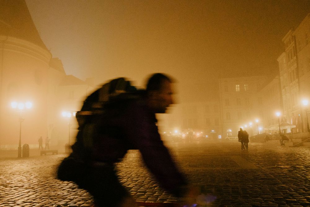 Atmospheric foggy street scene at night with golden lighting creating a moody urban landscape.