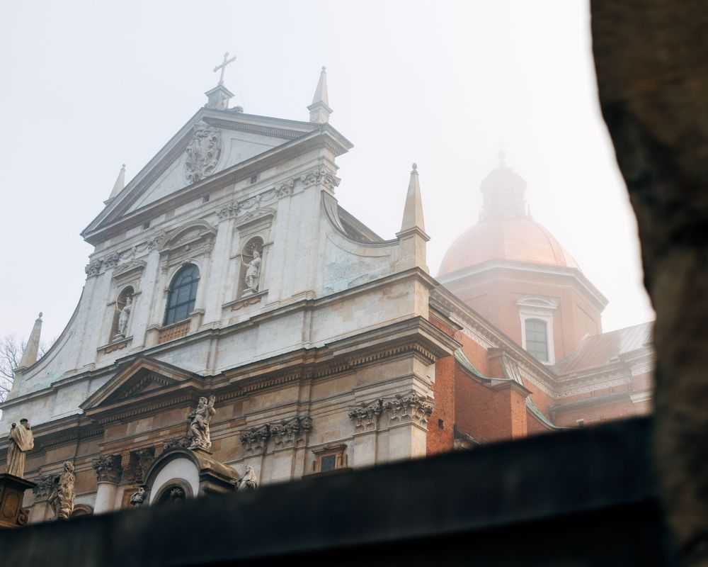 Historic church spires and ornate architecture emerging through morning fog.