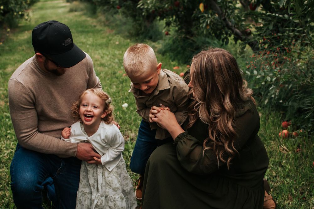 A family shares genuine laughter together in an outdoor garden setting in Tri Cities, Washington.