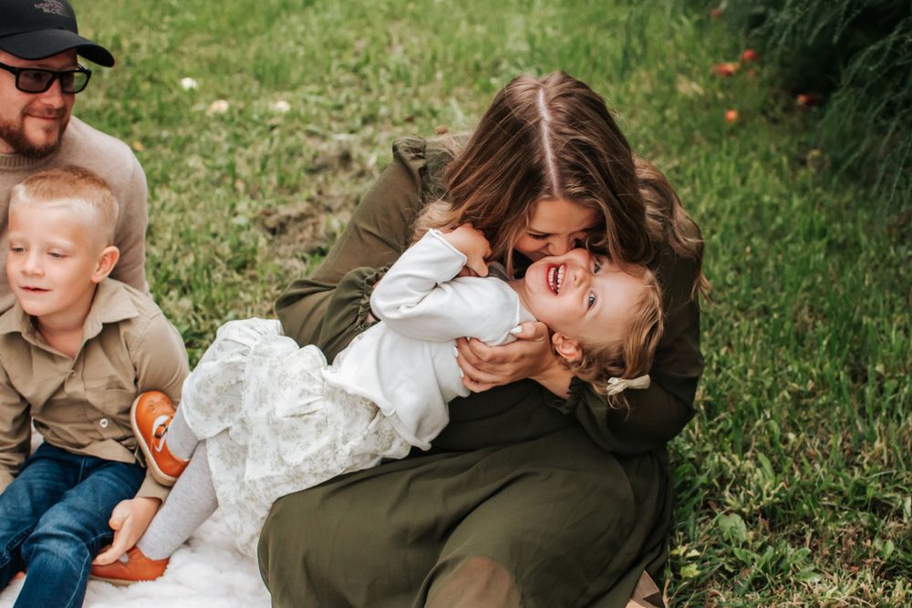 A tender family moment captured during an outdoor photo session in an orchard in Benton City, Washington..