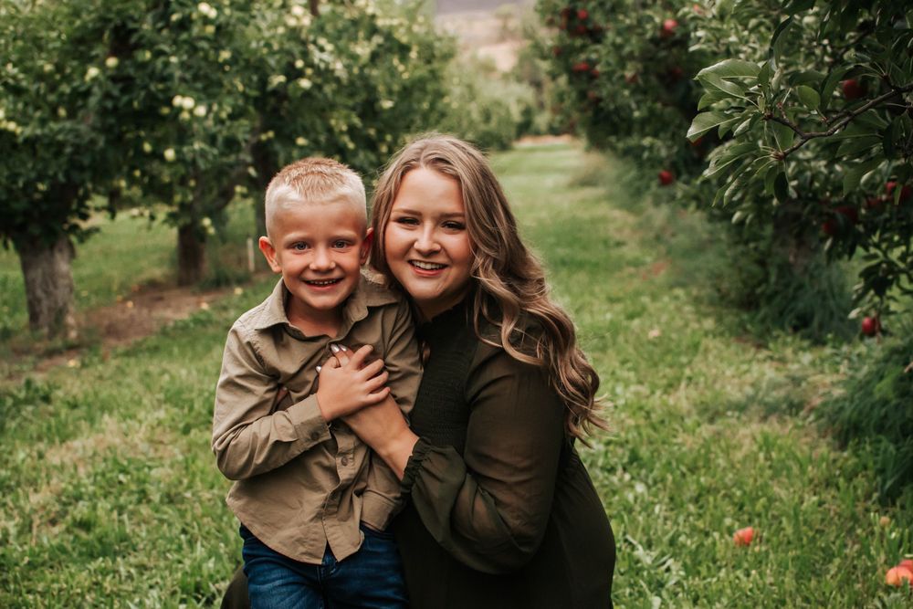 A sweet mommy and me embrace captured in an orchard during fall in Benton City, Washington.