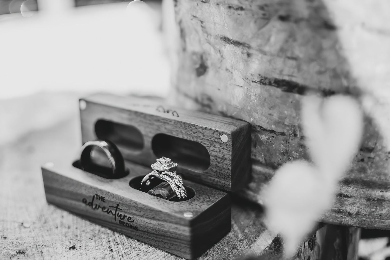 A rustic wooden ring box containing wedding bands photographed in black and white in Oregon.