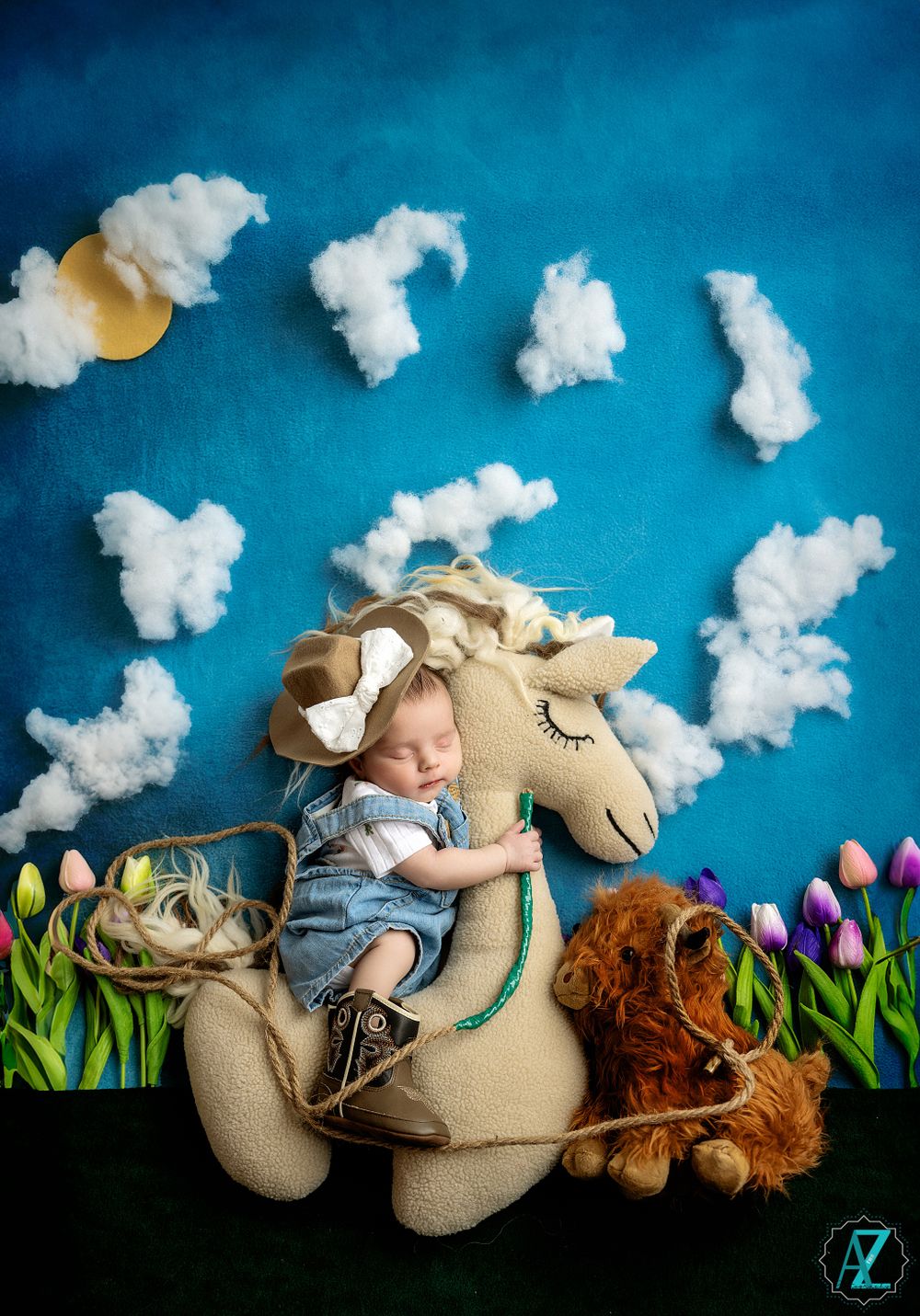 Sleeping baby on plush horse surrounded by cotton clouds and tulips against blue background.