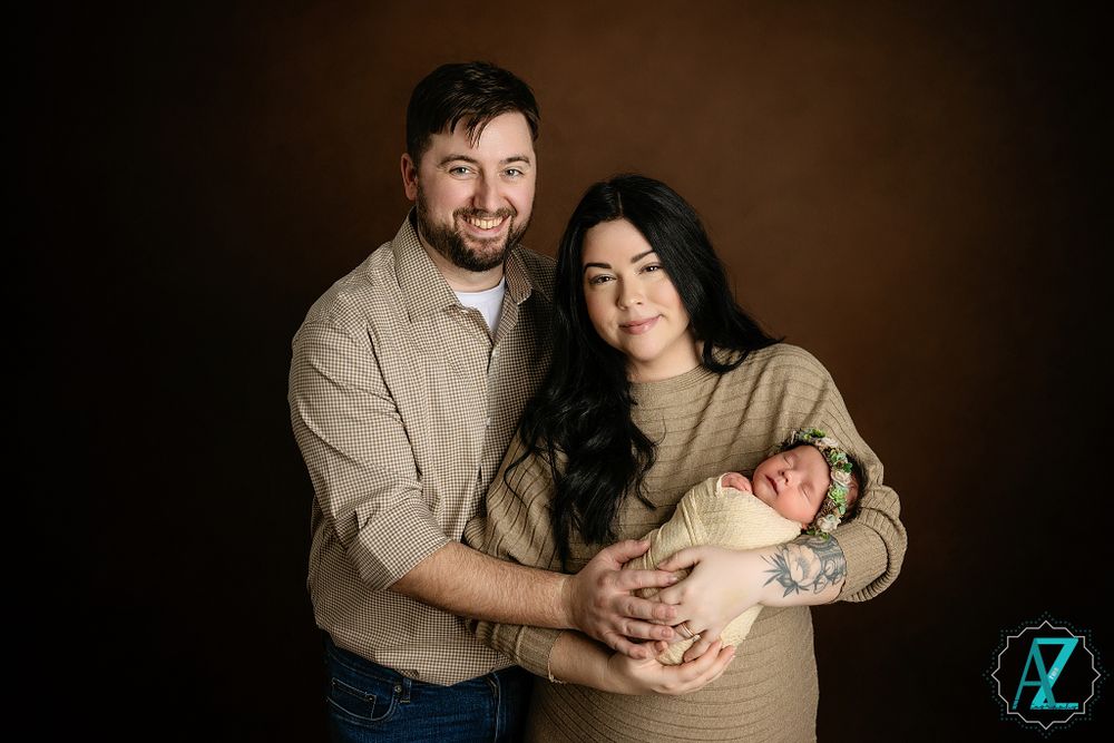 Professional studio portrait against brown backdrop with neutral tones.