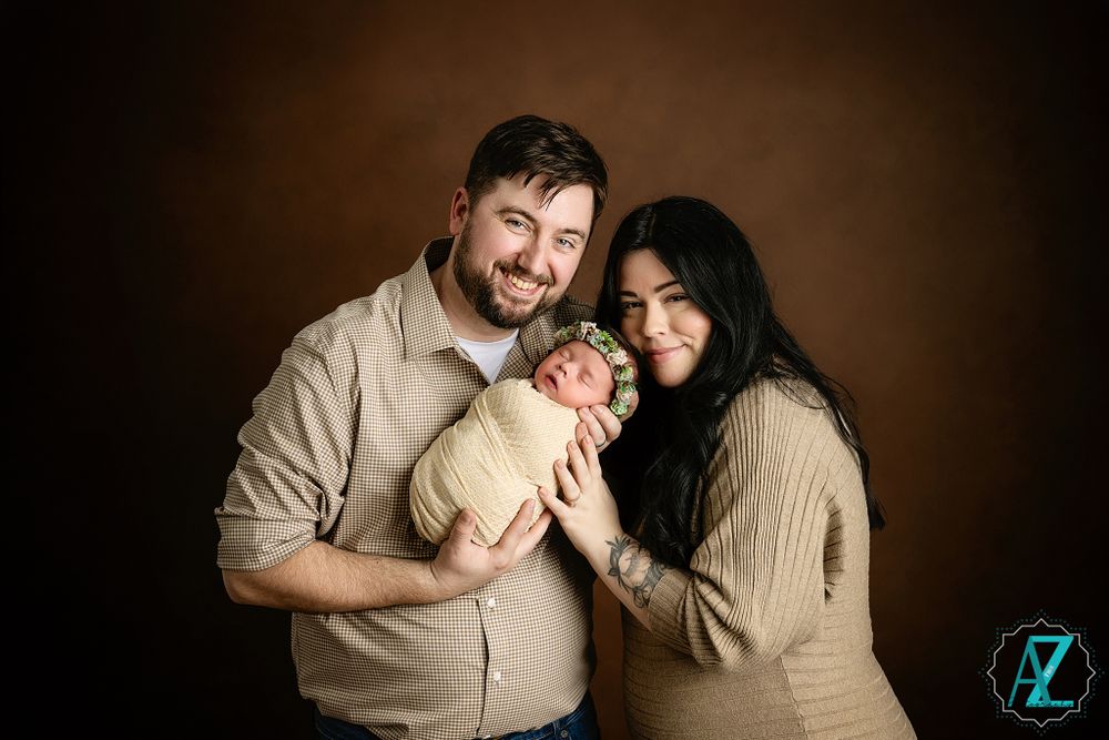 Joyful family portrait with natural expressions against brown backdrop.