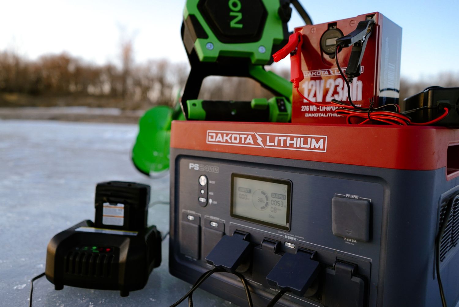Dakota Lithium power station with green work light and red battery pack displayed on icy surface.