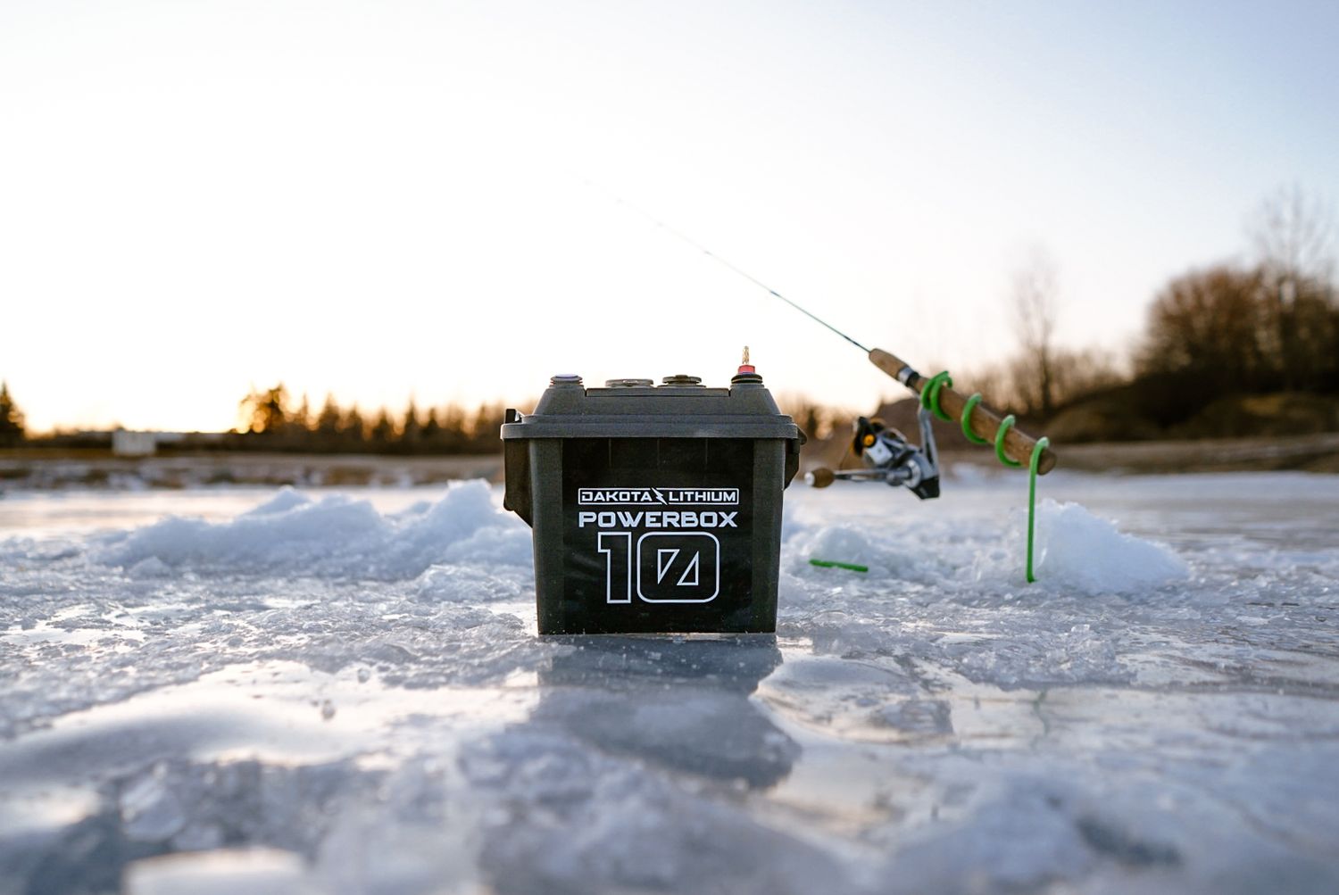 Black Powerbox 174 ice fishing equipment shown in snowy winter landscape.
