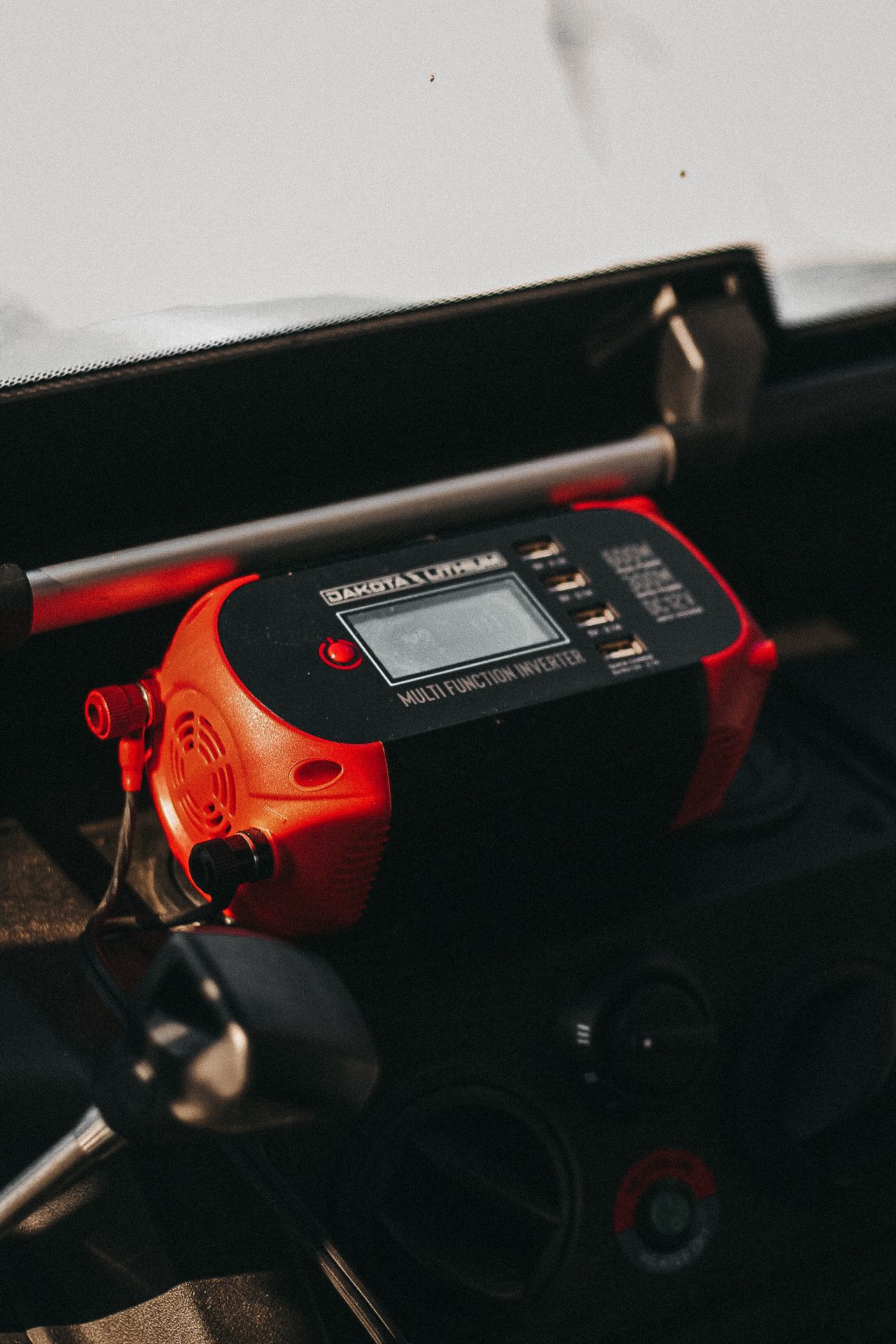 Close-up of red Dakota Lithium power bank device in low light conditions.