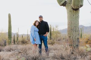 People exploring a desert trail surrounded by tall saguaro cacti.