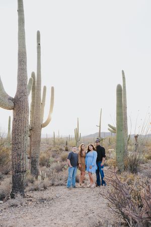 Family photo session among giant saguaro cacti in Arizona desert landscape.