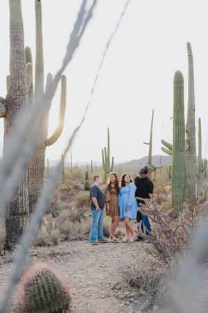Casual group portrait in desert environment framed by tall saguaro cacti.